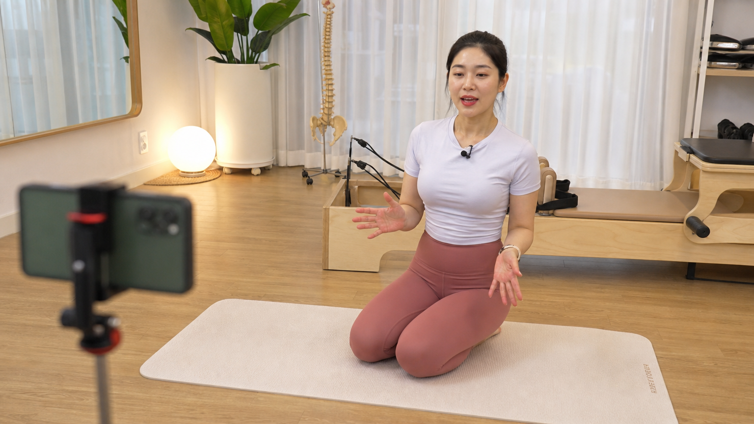 잘 갖춰진 스튜디오에서 고화질 카메라로 온라인 클래스를 진행하는 한국인 필라테스 강사