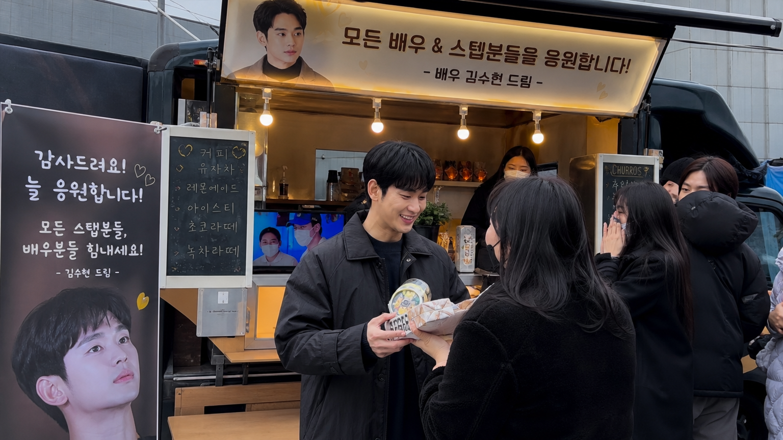 드라마 촬영장에서 한국 배우가 간식차를 받으며 스태프들과 따뜻하게 교류하는 모습