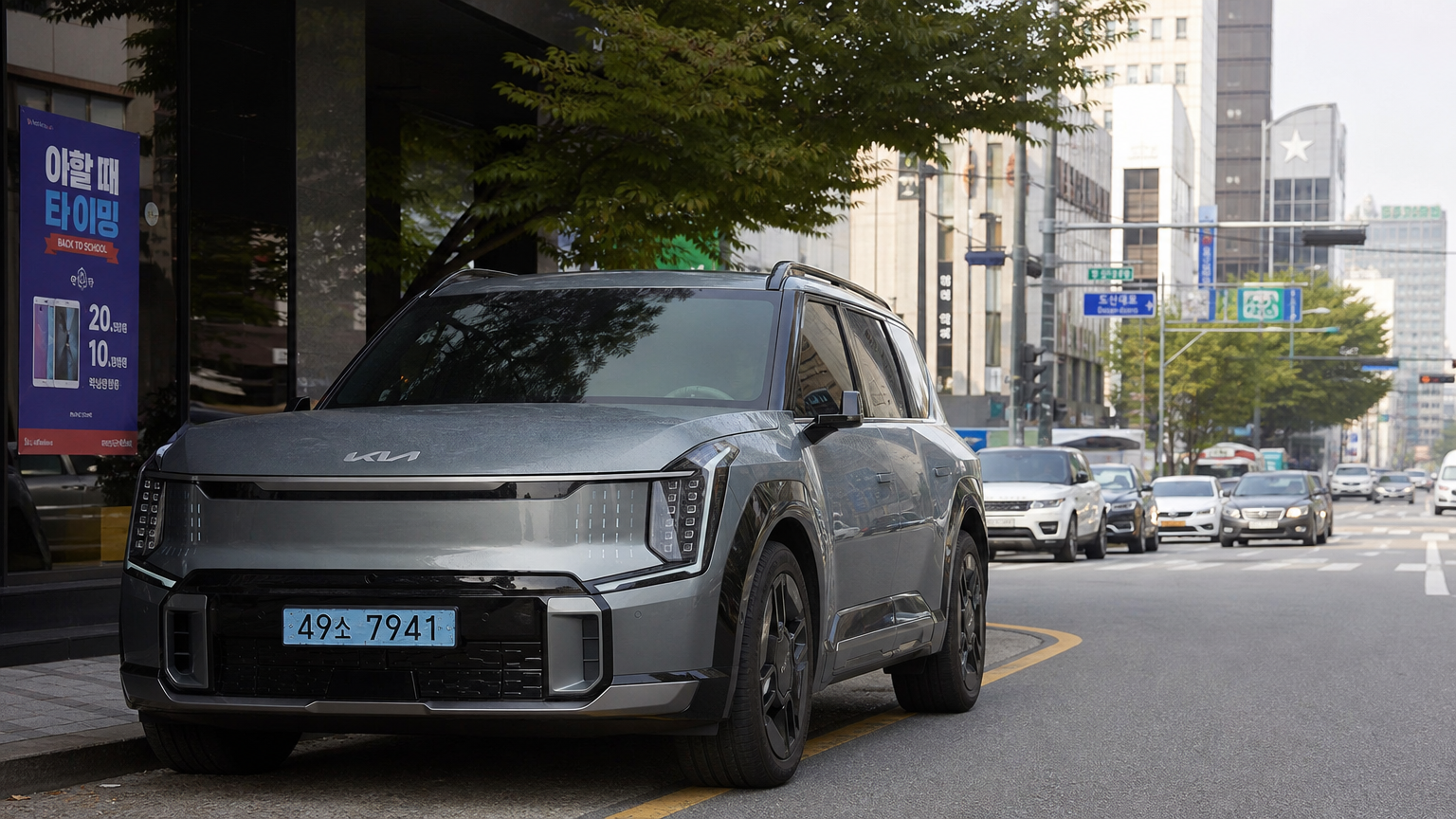 현대적 도시 환경 속 도로에 주차된 기아 대형 전기 SUV EV9의 인상적인 모습