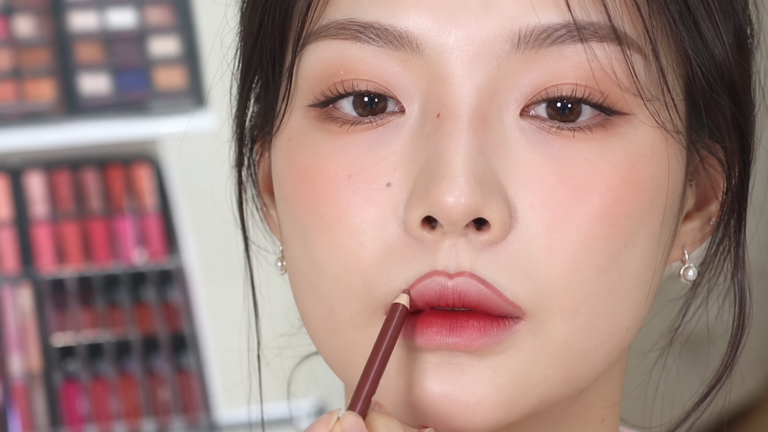 입술을 강조하는 메이크업을 하는 여성의 클로즈업 모습