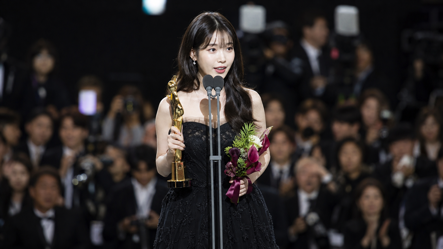 시상식 무대에서 상을 받고 있는 젊은 여배우
