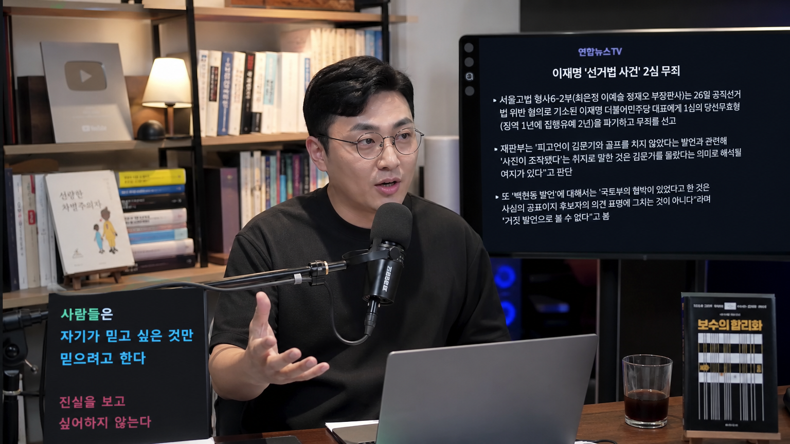 현대적인 한국 남성이 마이크 앞에서 방송하는 모습, 책과 디지털 화면이 있는 배경