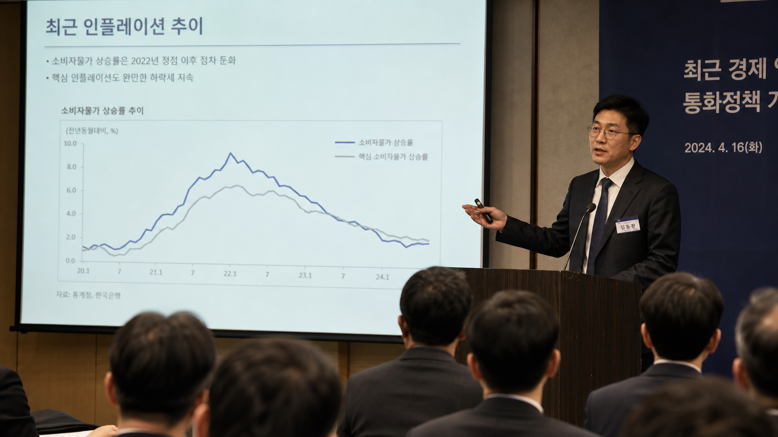 한국 경제학자가 인플레이션 추세를 그래프로 설명하는 세미나 장면