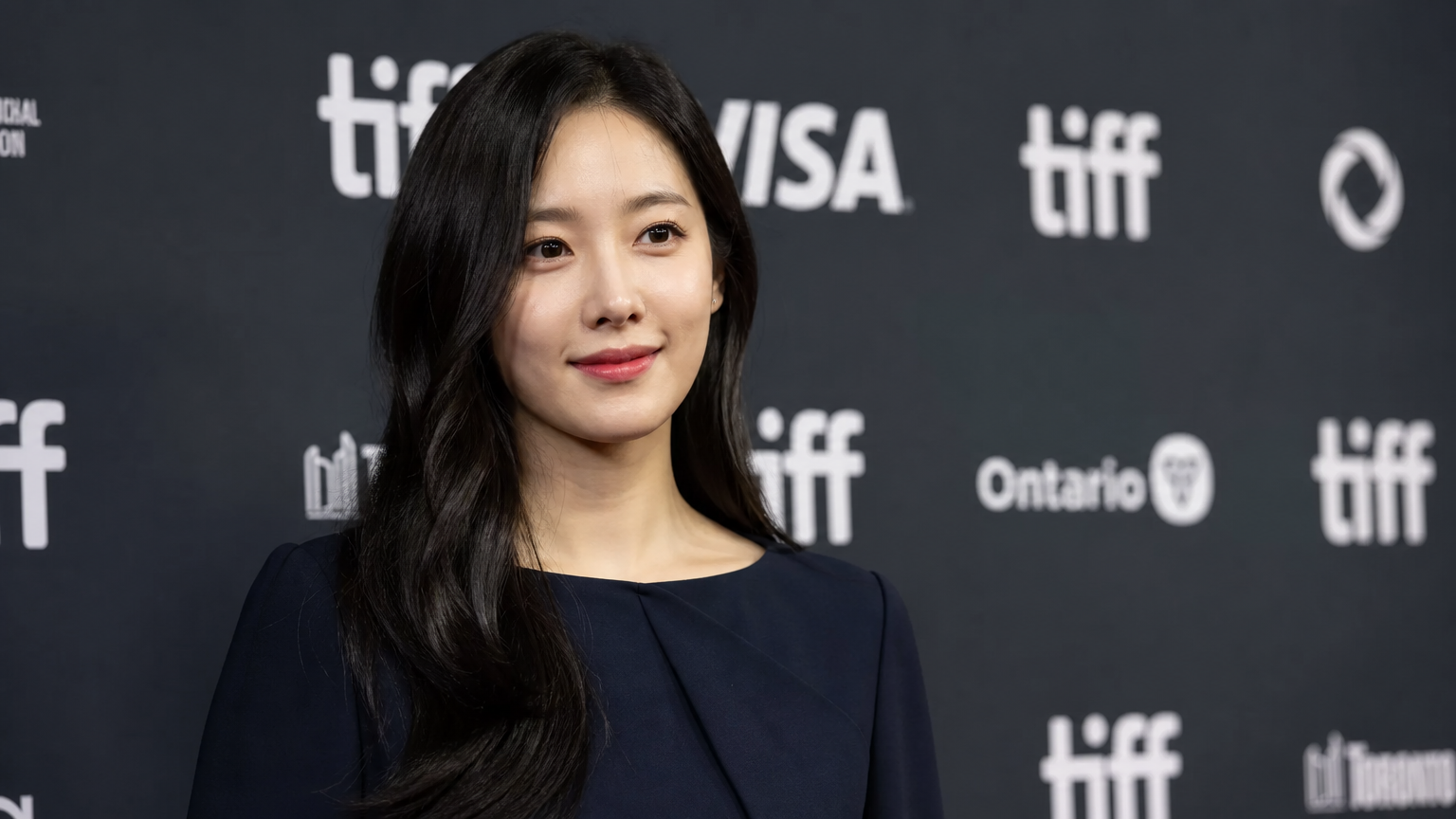 국제 영화제 행사에서 단정한 네이비 의상을 입은 여배우
