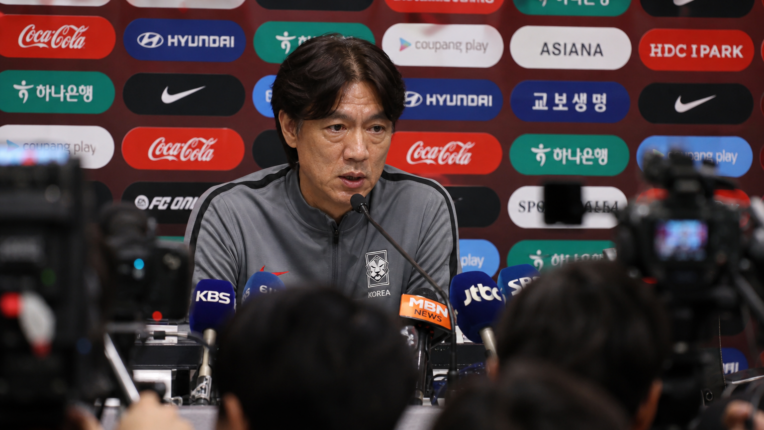 기자 회견에서 카메라 앞에 앉아 있는 한국인 축구 감독