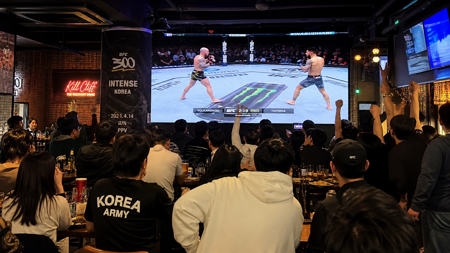 스포츠 바에서 UFC 경기를 관람하며 환호하는 팬들