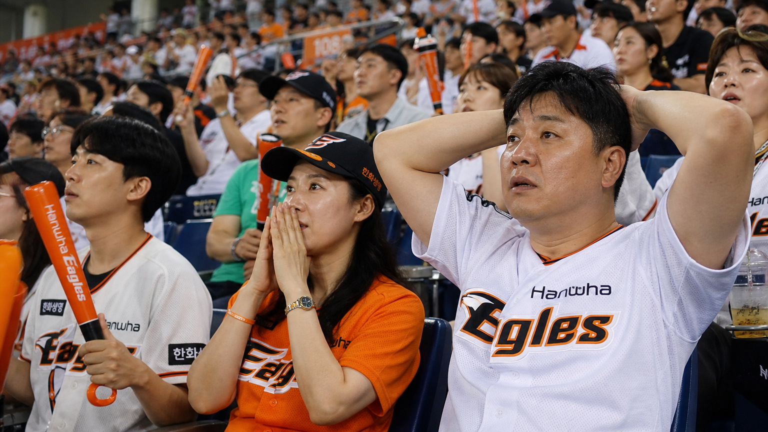 야구 경기장에서 경기를 긴장감 있게 지켜보는 팬들