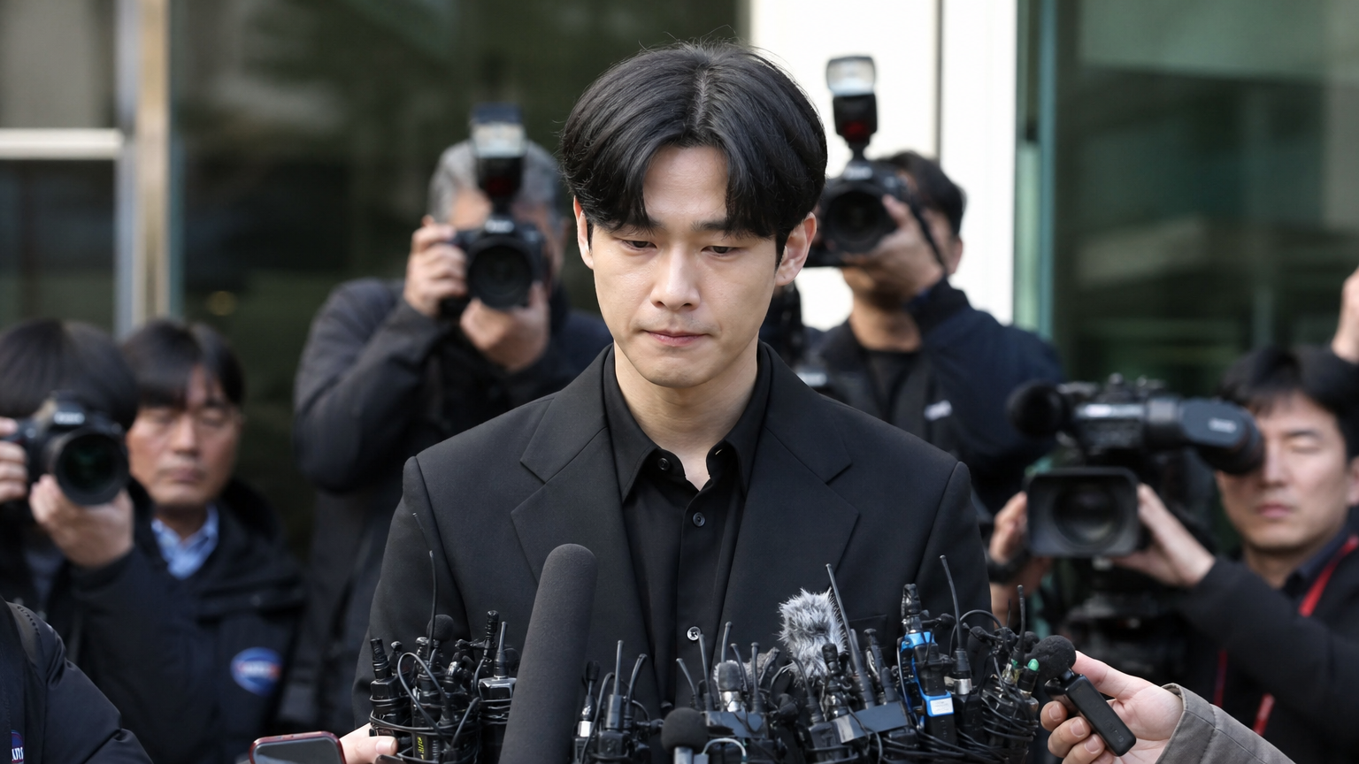 기자회견 자리에서 사과와 인정을 표현하는 젊은 한국 남성의 진지한 모습
