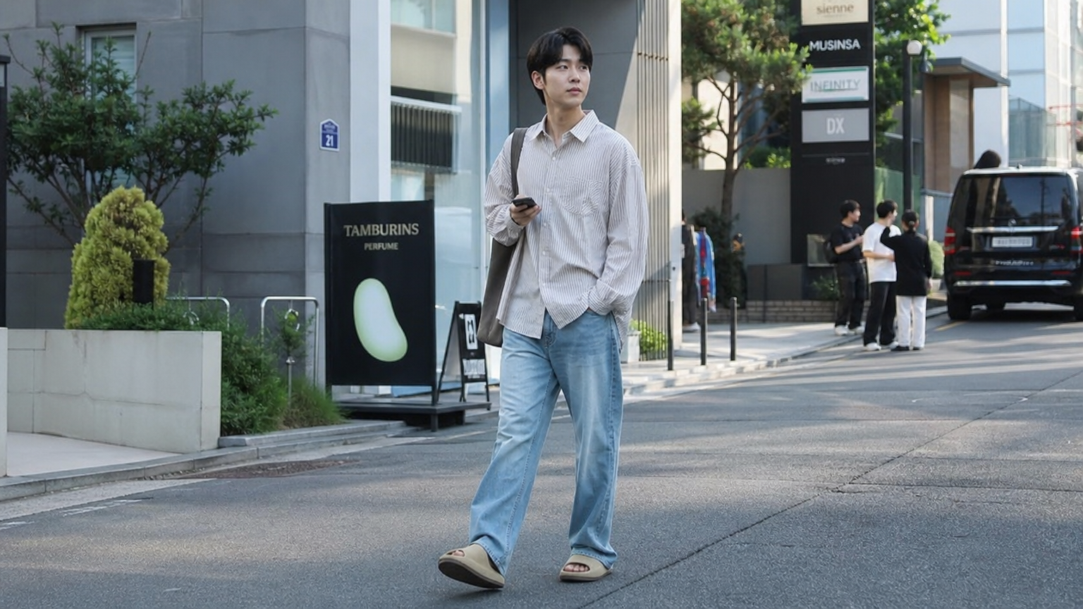 생기 넘치는 도시 거리에서 오버사이즈 셔츠와 데님 팬츠를 입고 자신감 있게 걷는 남성