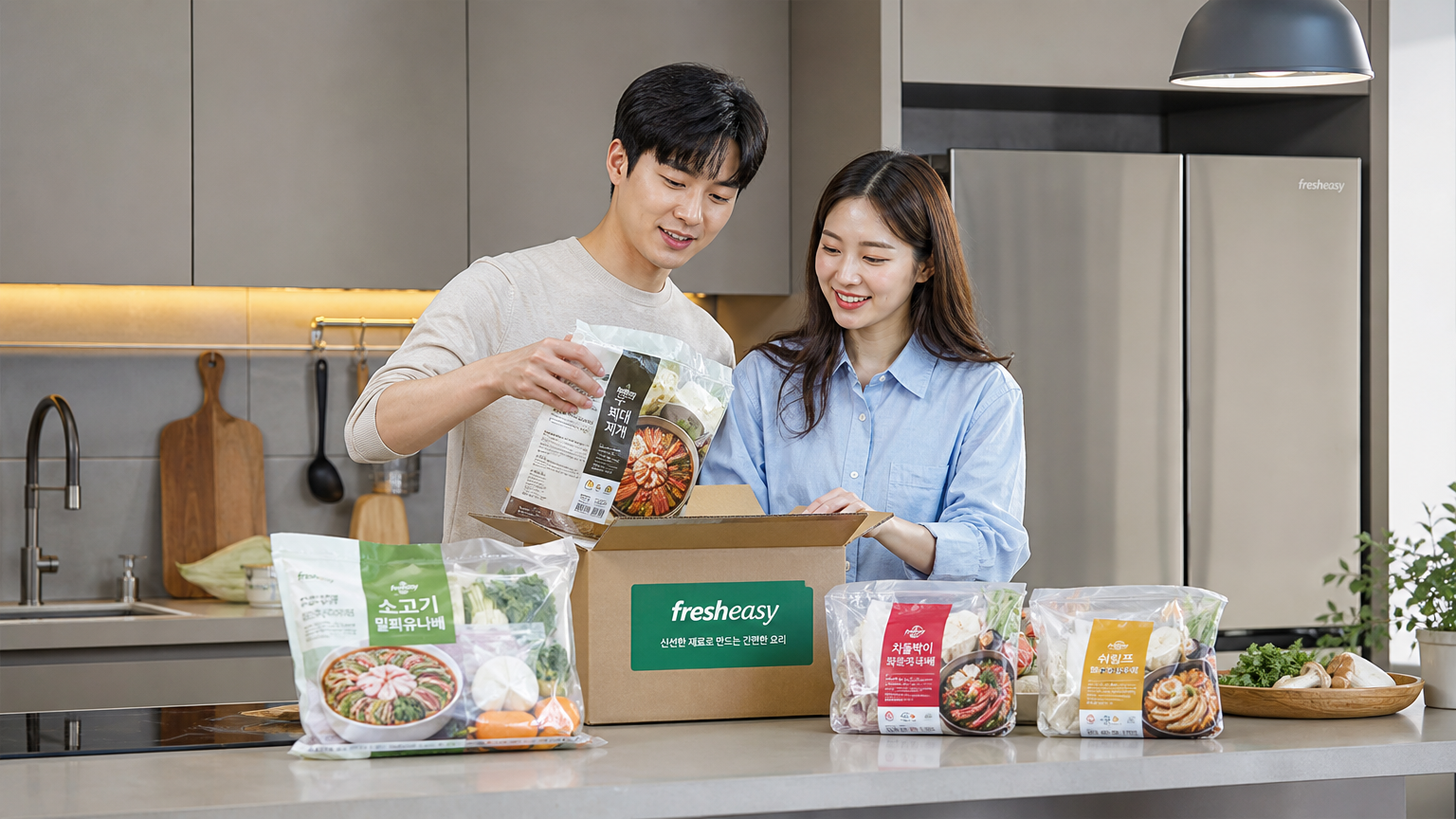 현대적인 주방에서 젊은 커플이 밀키트를 언박싱하는 모습