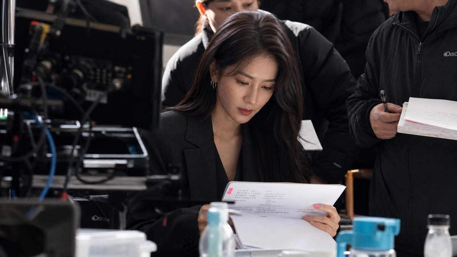 현대적인 세트장에서 대본을 보는 배우의 집중하는 모습