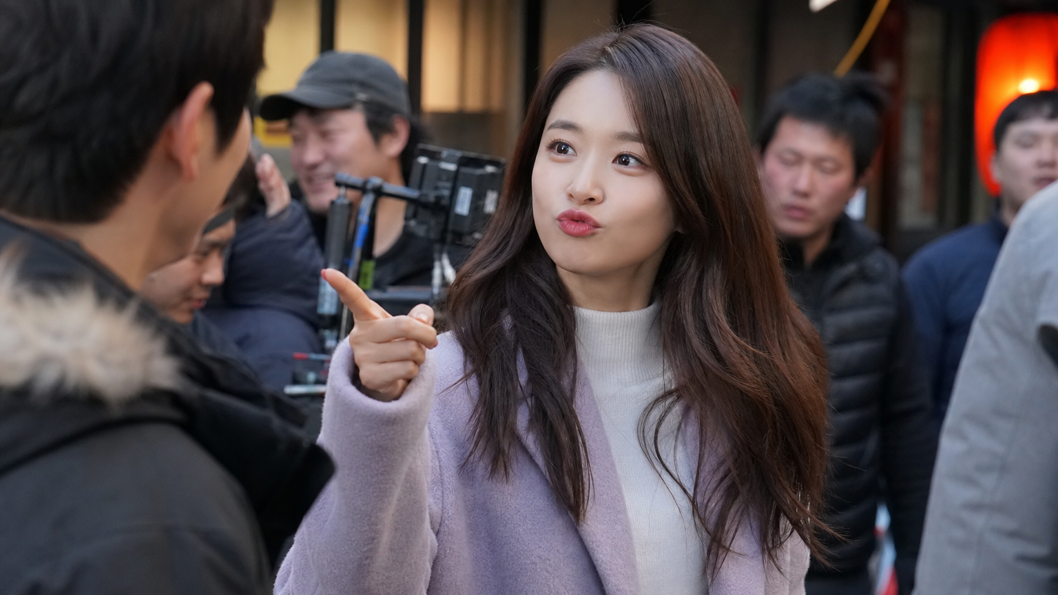 활기찬 촬영 현장에서 로맨틱 코미디 장면을 연기하는 여배우의 모습