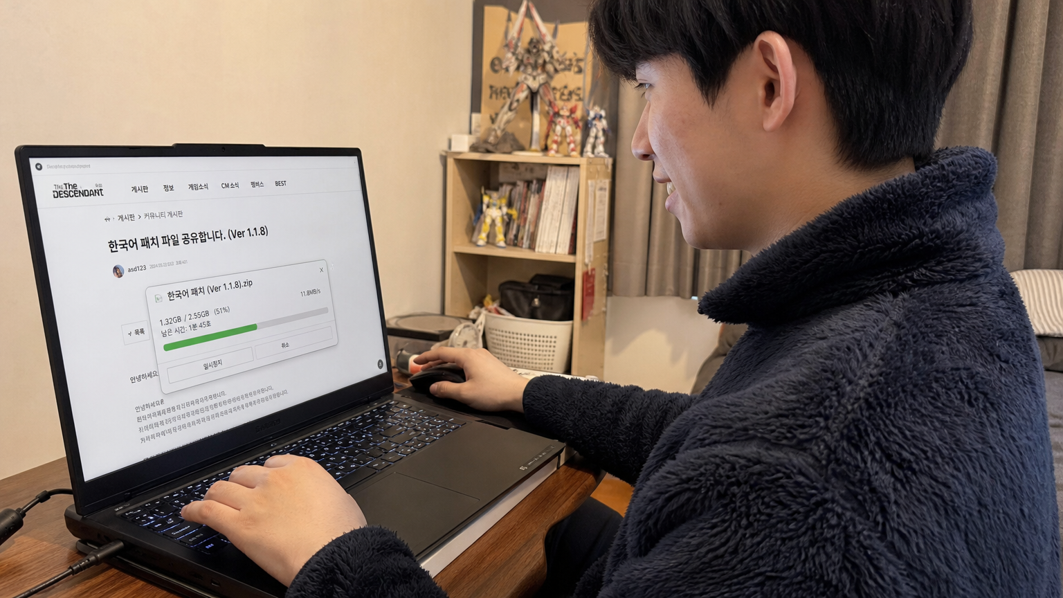 노트북으로 온라인 커뮤니티 사이트에서 언어 패치를 다운로드하는 모습