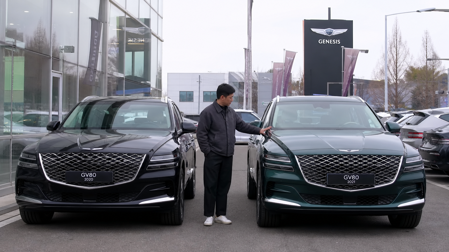 자동차 전문가가 2020년과 2021년식 두 대의 제네시스 GV80을 나란히 살펴보는 모습