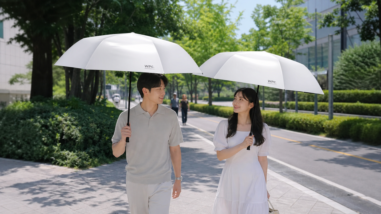 뜨거운 태양 아래 양산을 사용하여 주변 온도가 시원해 보이는 두 사람