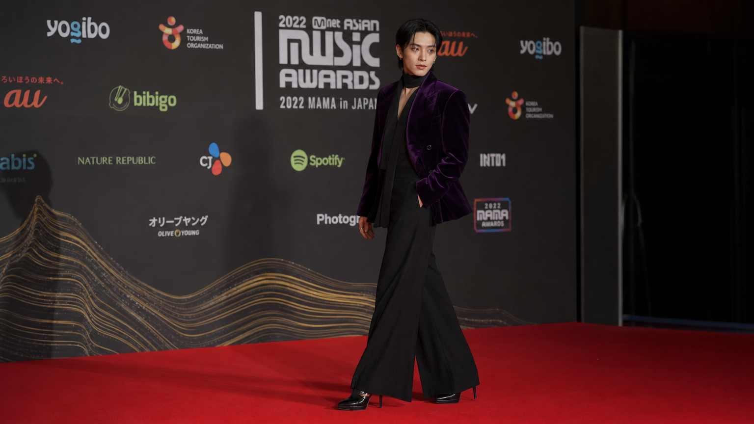 레드카펫 위에서 벨벳 재킷과 하이힐을 매치한 과감한 의상의 배우