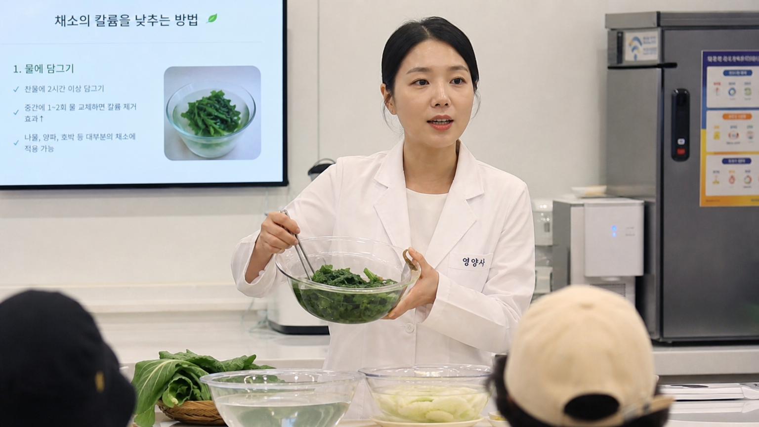 요리 수업에서 채소를 담가 칼륨 함량을 줄이는 방법을 설명하는 영양사