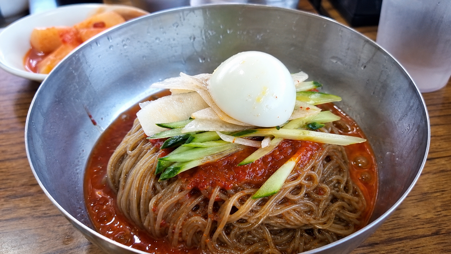 나무 테이블 위에 놓인 부산 밀면 한 그릇 클로즈업