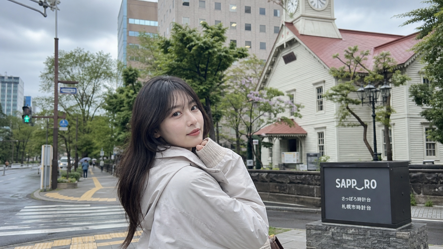 흐린 하늘 아래 가벼운 재킷과 긴팔 옷을 입고 있는 여성
