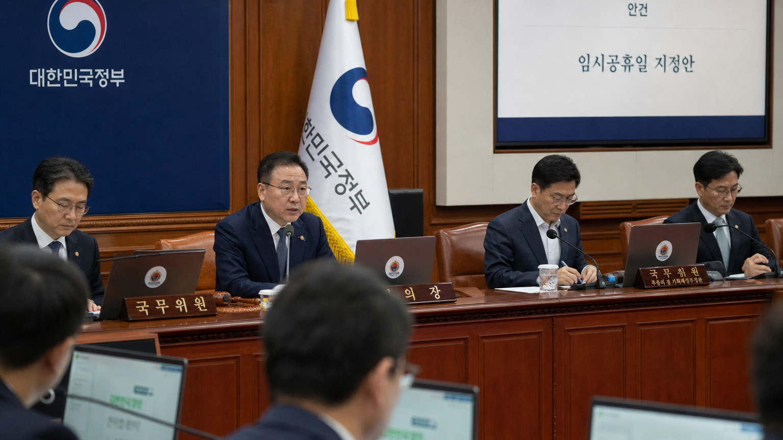 한국 정부 회의실에서 임시 공휴일 지정 여부를 논의하는 공무원들