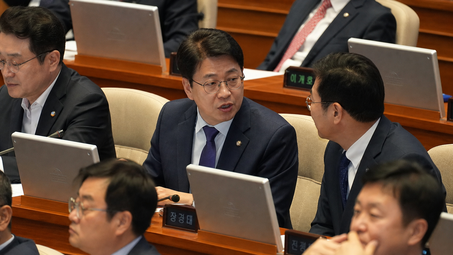 국회 회의장에서 다른 의원들과 토론 중인 한국 정치인의 모습