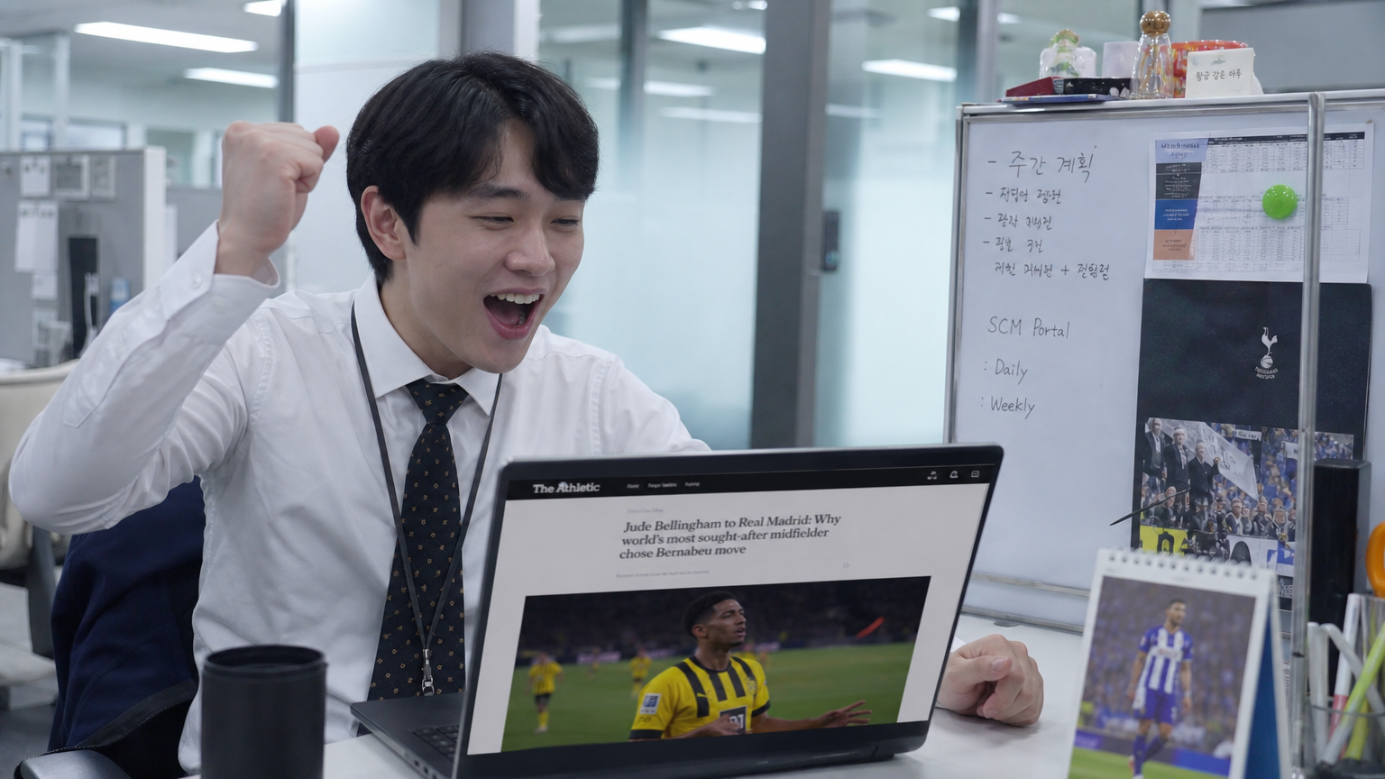 사무실 책상에서 레알 마드리드로 이적한 소식을 읽으며 기뻐하는 직장인