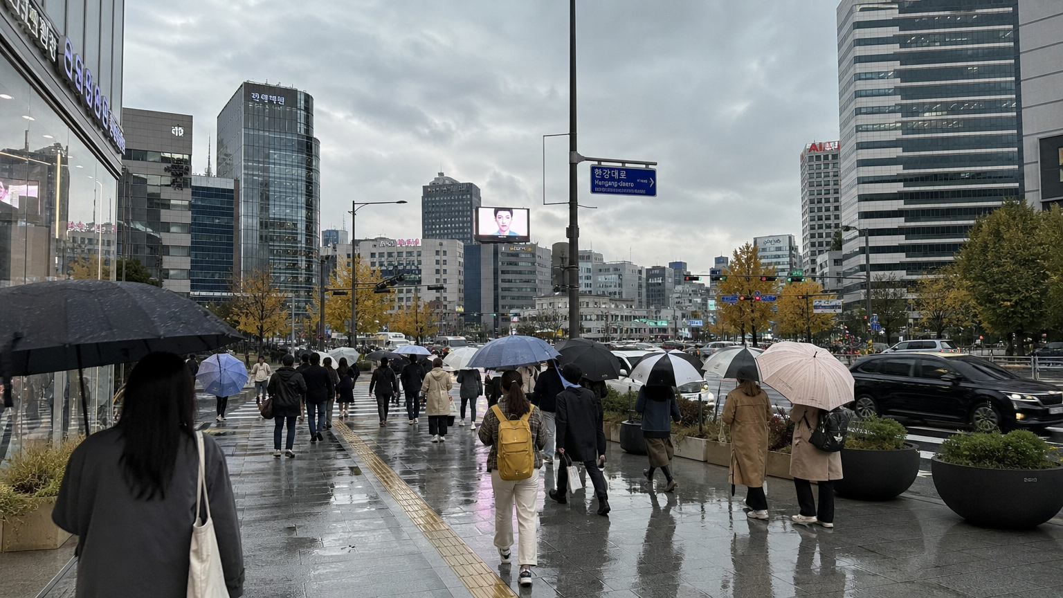 흐린 하늘 아래 우산을 든 사람들이 있는 한국 도시 풍경
