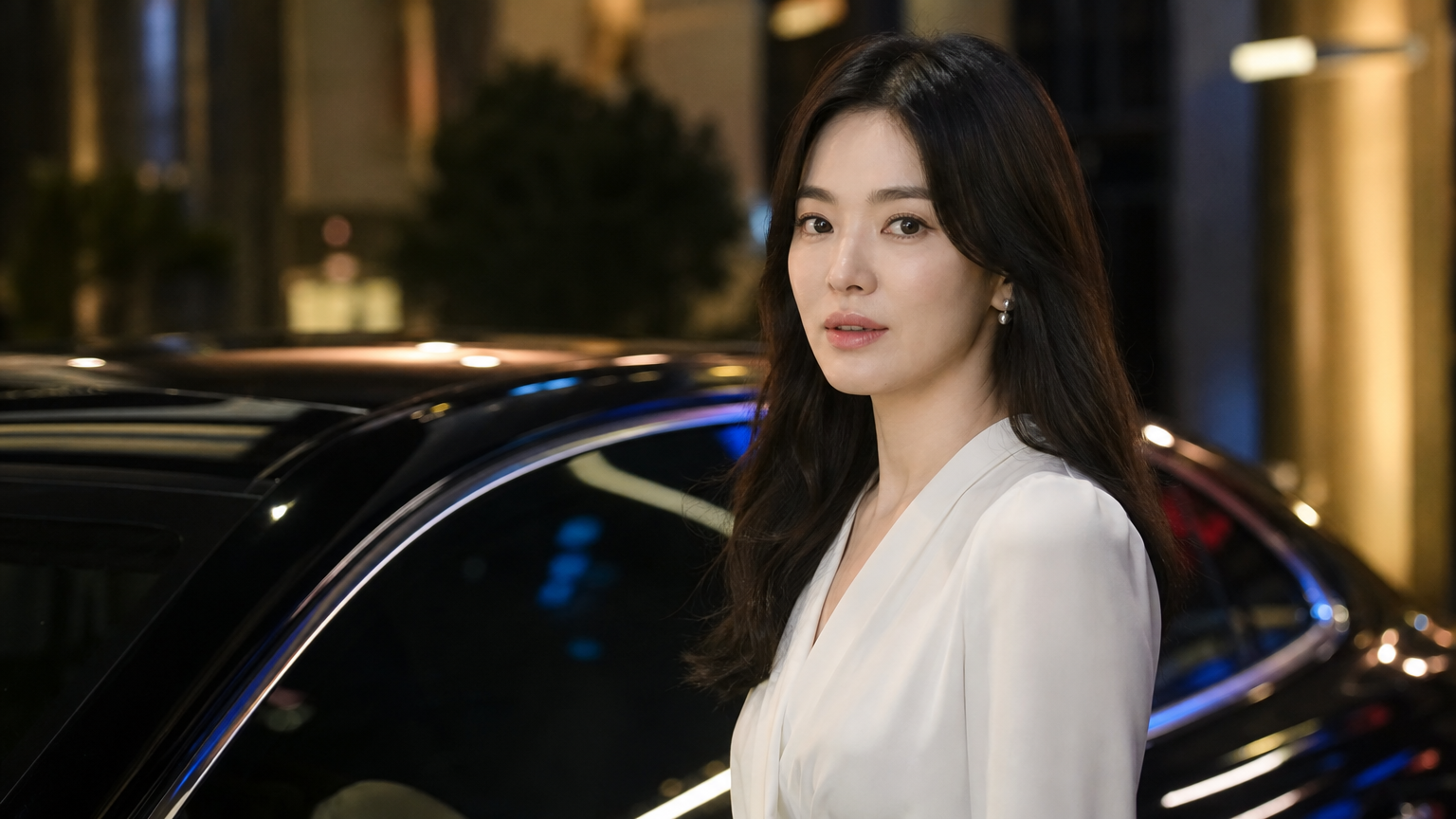 도시의 조명 아래 럭셔리카 옆에 서 있는 송혜교의 우아한 모습