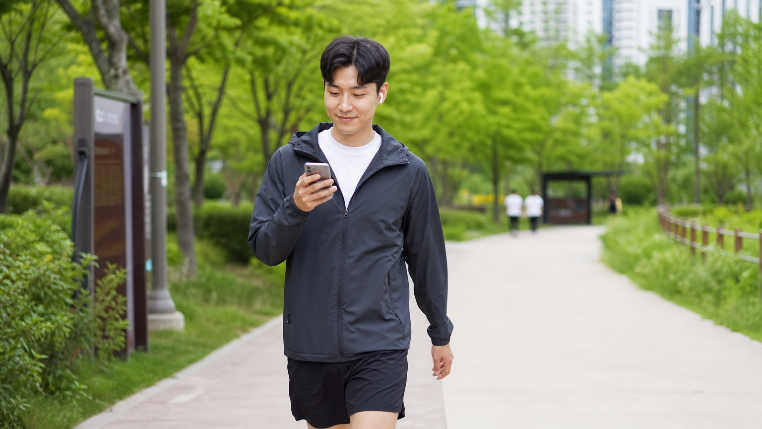 도시 공원에서 걷기 앱을 사용하는 한국인의 모습