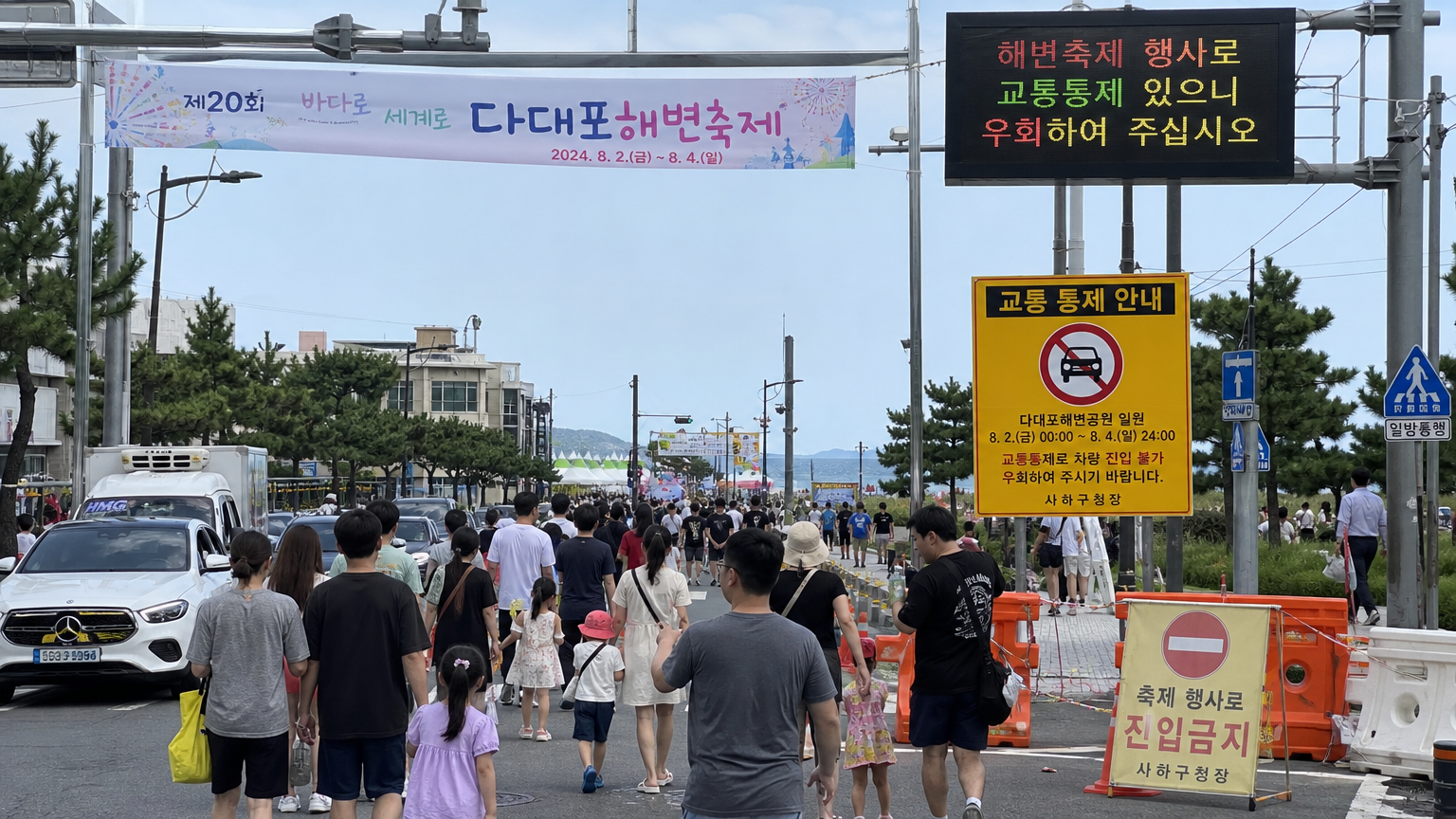 도로 폐쇄 표지판과 축제장을 향해 걷는 사람들로 붐비는 다대포 해변 인근 거리