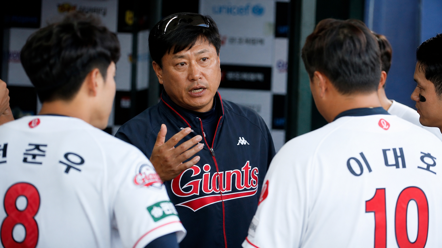 롯데 자이언츠 코치가 덕아웃에서 선수들과 전략 회의를 하는 장면