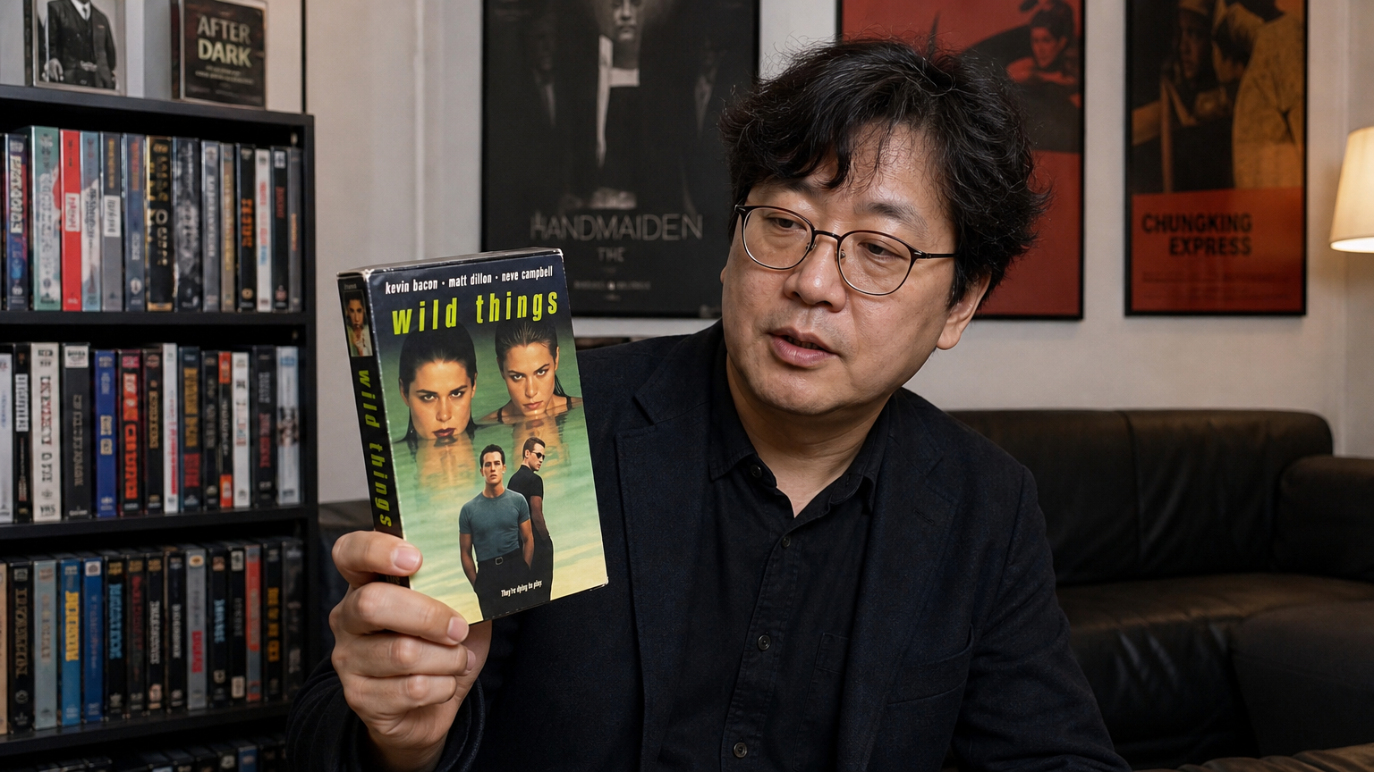한국 영화 평론가가 '와일드 씽' VHS 테이프를 들고 있는 현대적인 거실