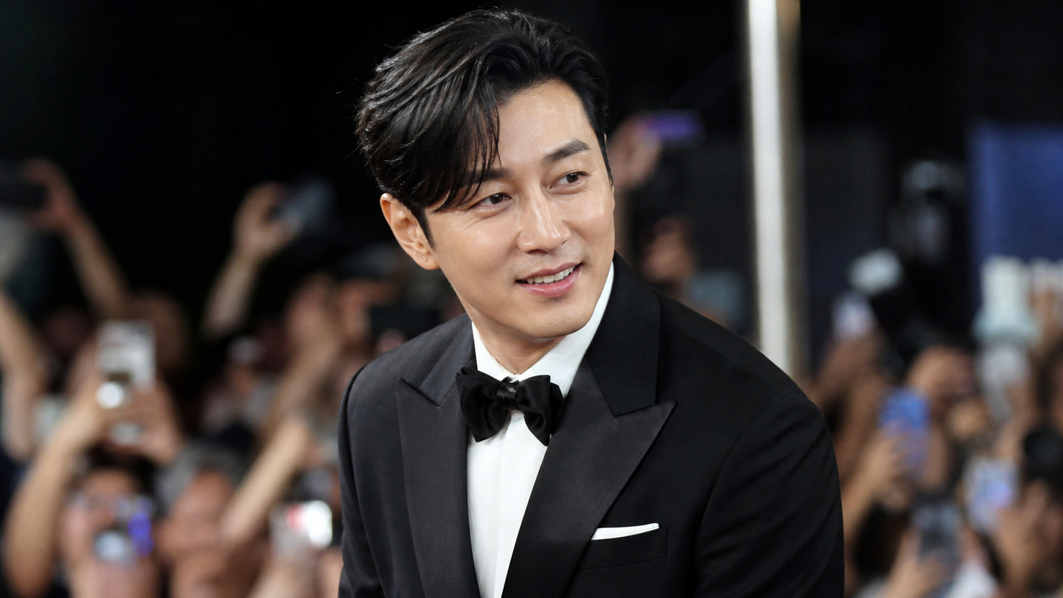 잘 정돈된 피부와 몸매를 가진 중년 남성이 공식 석상에서 많은 사람들의 시선을 끄는 모습