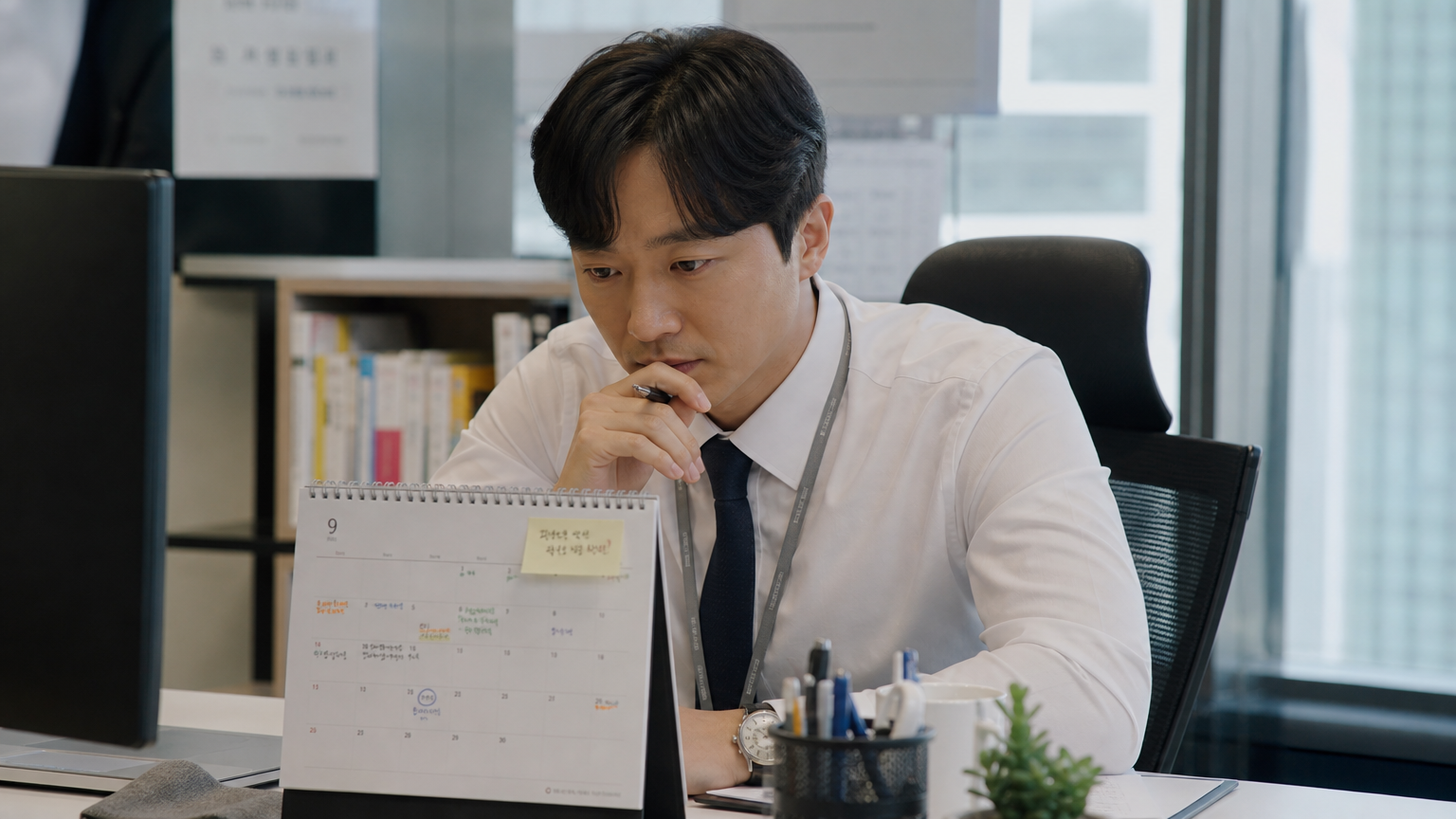 현대적인 사무실에서 책상 위 달력을 보며 휴일을 계획하는 직장인의 모습