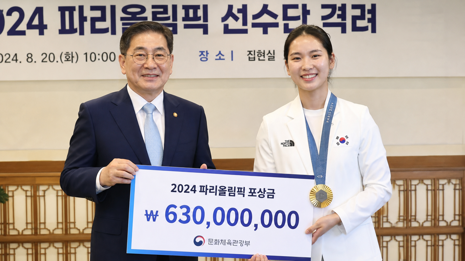 정부 관계자로부터 상금을 받는 한국 금메달리스트의 공식적인 순간