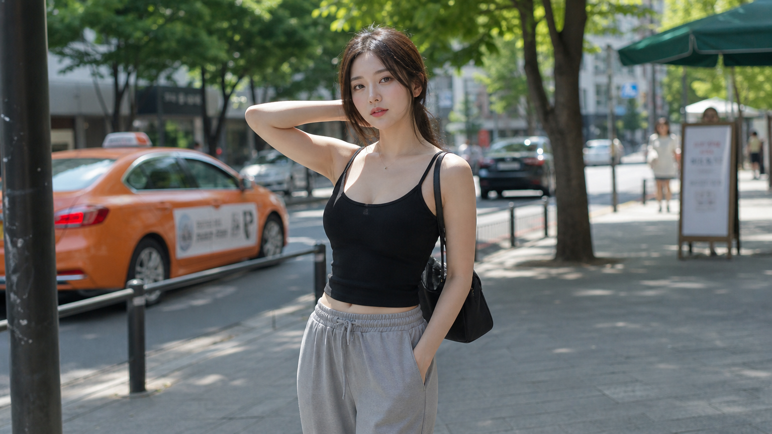 현대적인 한국 여성이 블랙 탱크탑과 회색 팬츠를 입고 거리에서 편안한 자세로 서 있는 모습