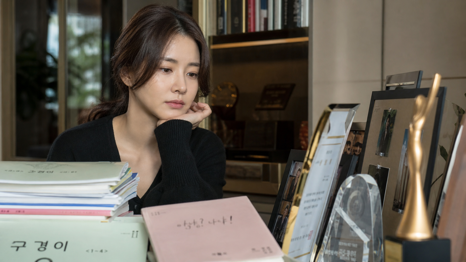 집 서재에서 과거 대본과 상을 보며 깊이 생각하는 여배우 모습
