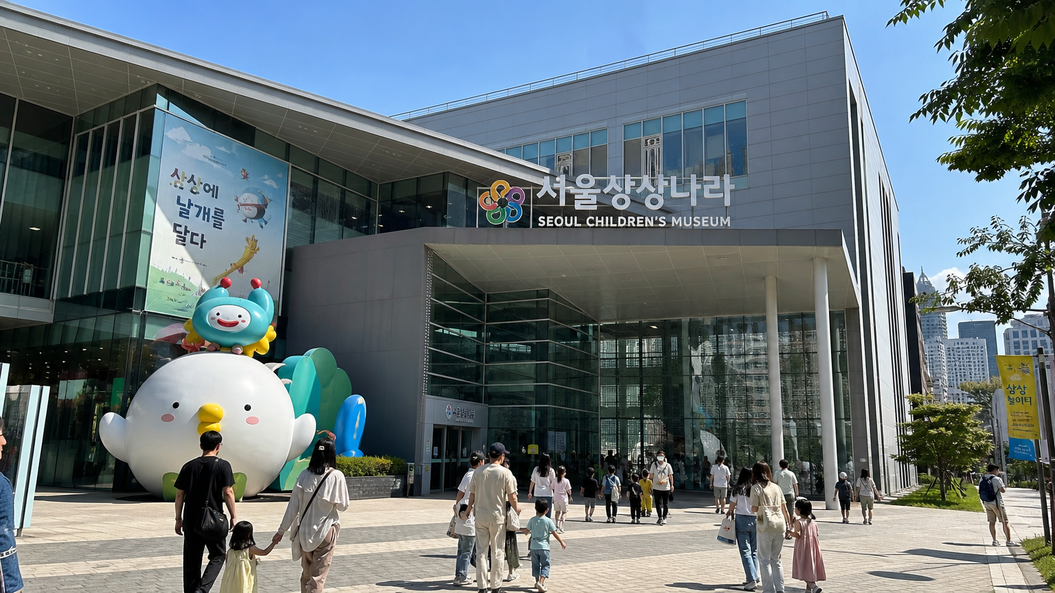 서울에 있는 대형 현대식 어린이 박물관 외관에 가족들이 입장하는 모습