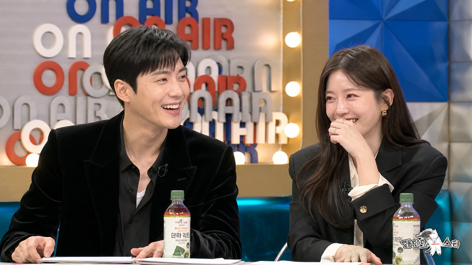 두 배우가 스튜디오에서 대화를 나누며 웃고 있는 모습