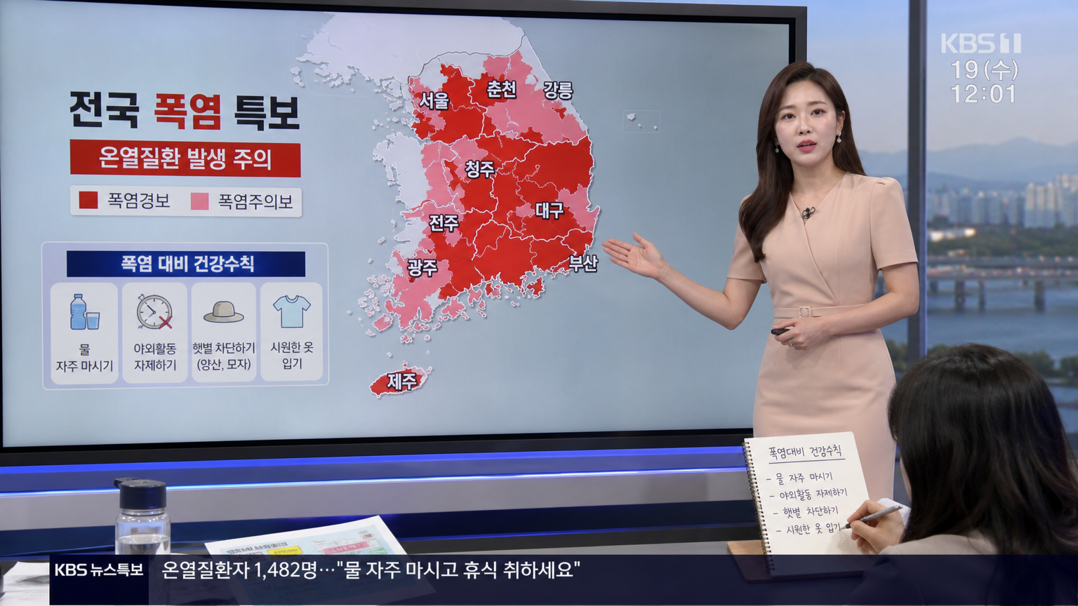 기상캐스터가 폭염 경보 지도를 보여주고 사람들이 메모하는 장면