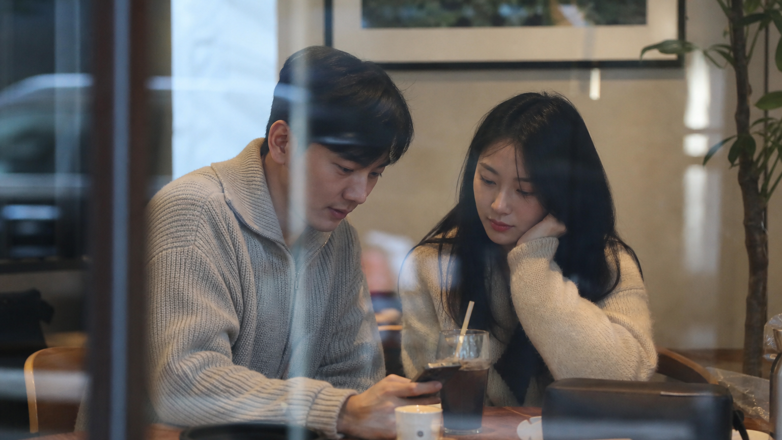 한국의 현대적 연예인 커플이 조용한 카페에서 사적인 시간을 보내는 모습