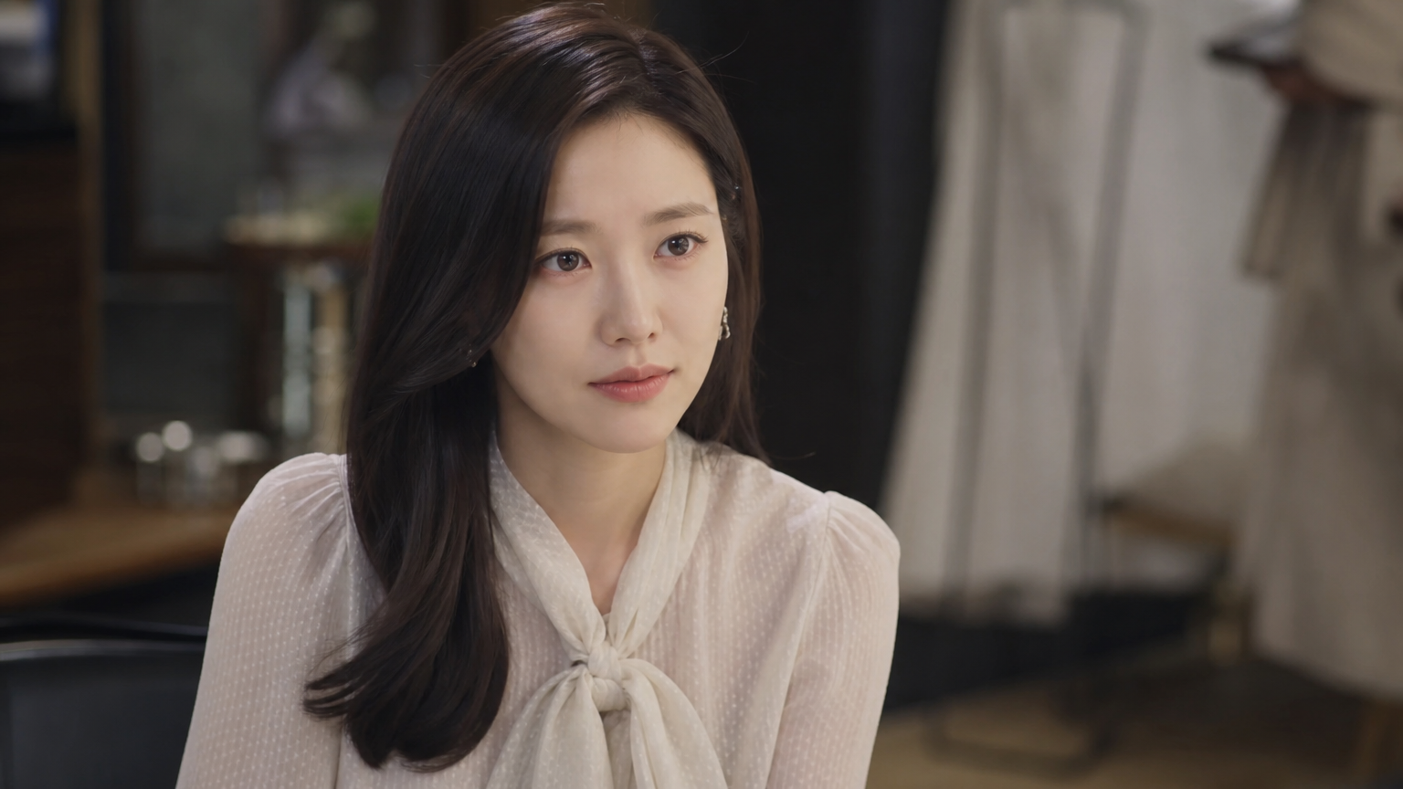 드라마 촬영 현장에서 스타일리시한 블라우스를 입고 있는 배우의 모습