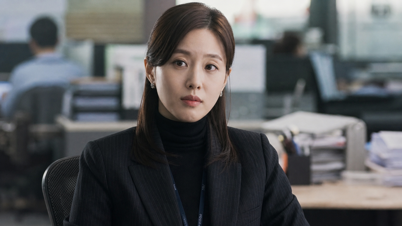 직장인의 복장을 한 채 중요한 사건에 휘말린 캐릭터를 연기하는 배우