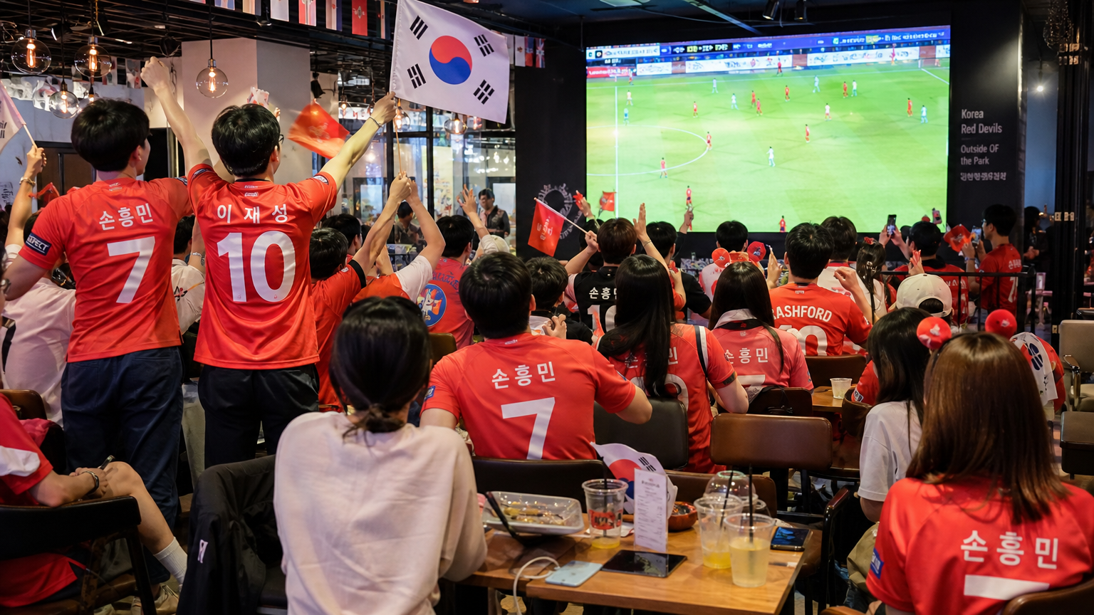 축구 팬들이 카페에서 대형 화면으로 경기를 응원하는 모습
