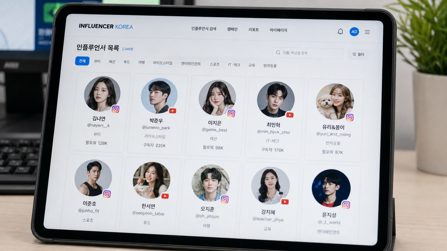 사무실 환경에서 태블릿 화면에 다양한 한국 인플루언서 프로필이 보이는 모습