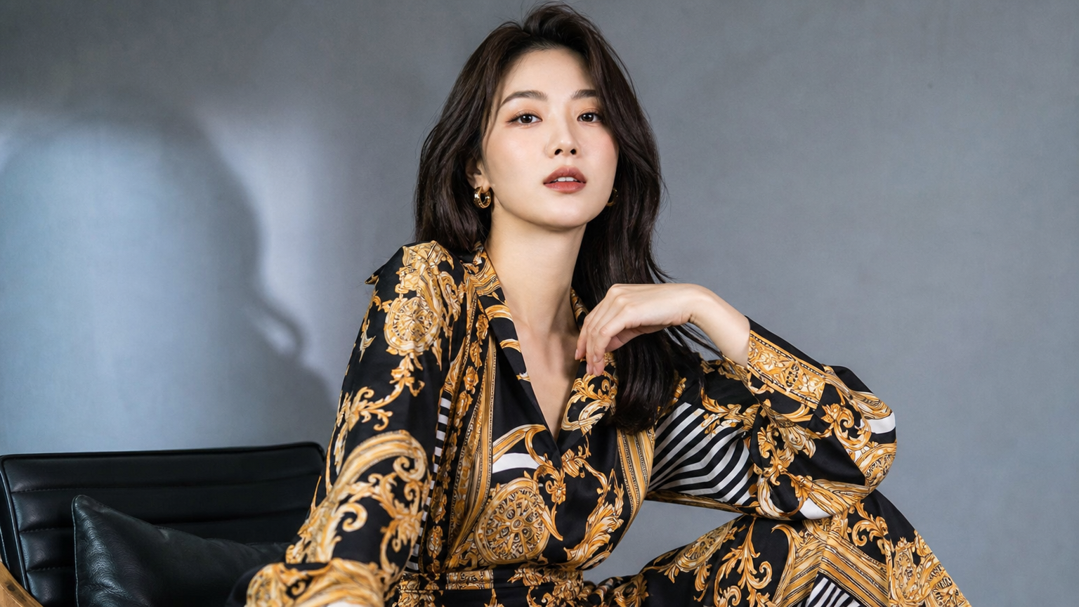 대담한 패턴이 있는 우아한 의상을 입고 카리스마 있게 포즈를 취하는 여성