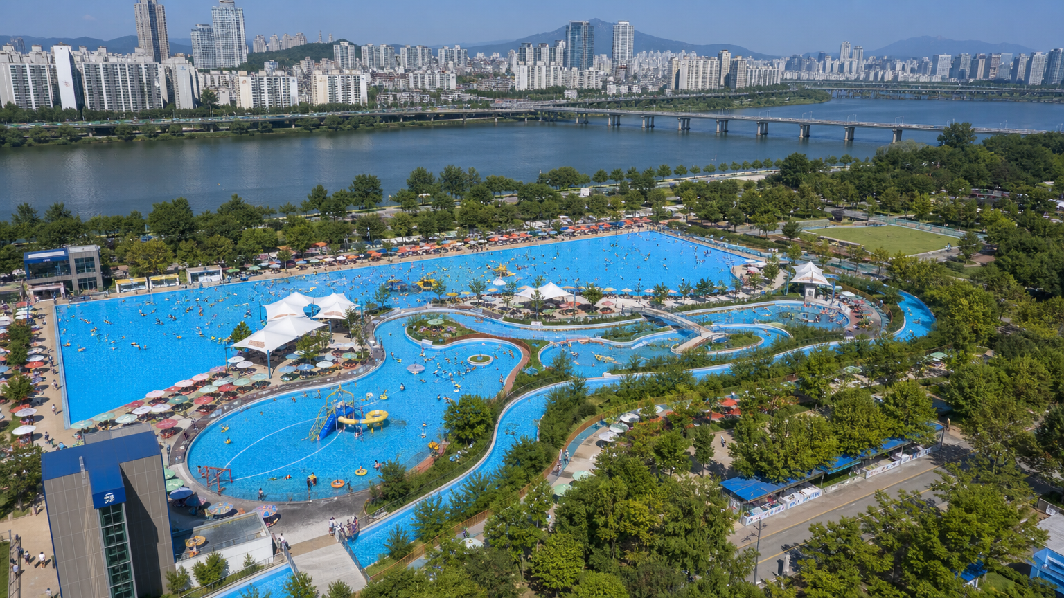 서울 도시 풍경 속 유수풀과 아쿠아링을 갖춘 뚝섬 한강공원 수영장의 항공 사진
