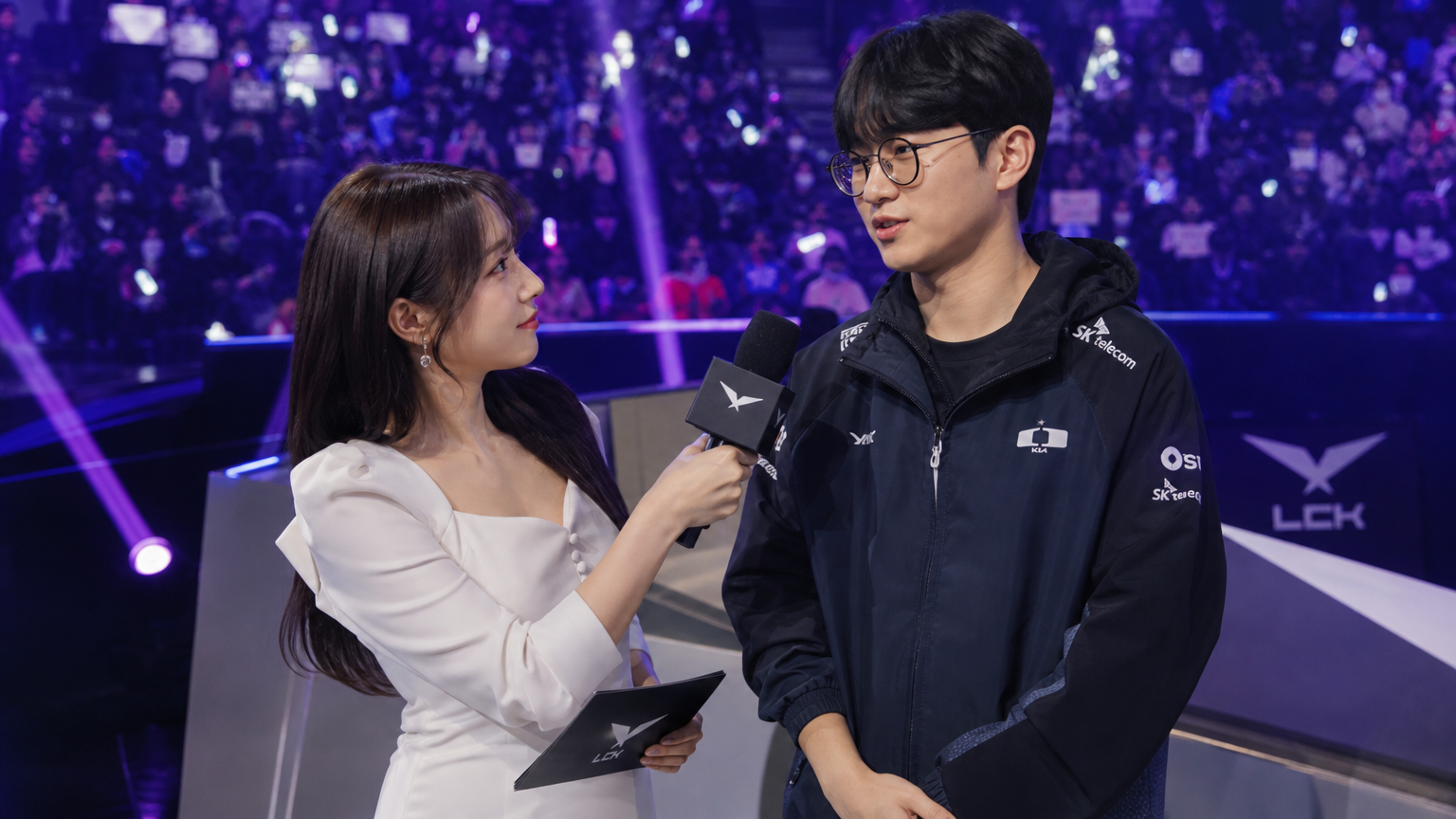 e스포츠 행사 무대에서 게이머를 인터뷰하는 여성 진행자