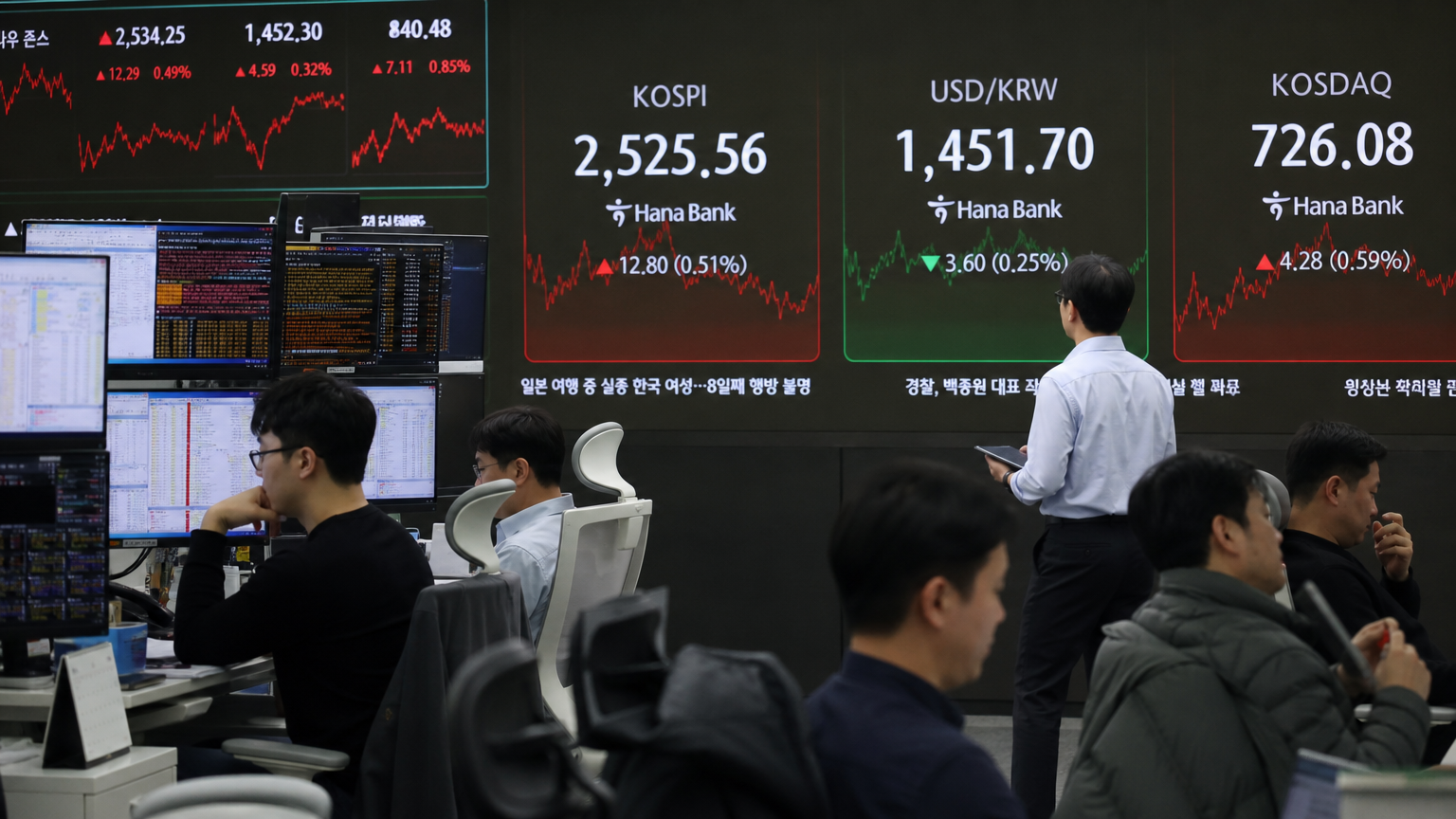 현대적인 한국 증권 거래소 내부, 대형 디지털 스크린에 표시된 반도체 주식과 데이터를 분석하는 트레이더들