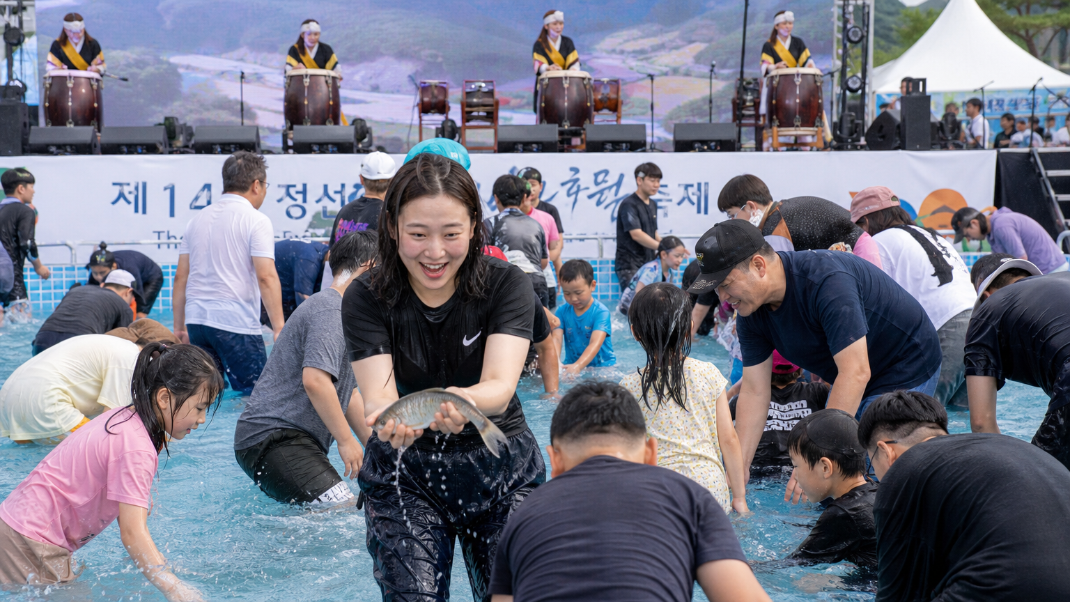 무대 공연과 맨손으로 전어 잡기 체험을 하는 참가자들의 모습